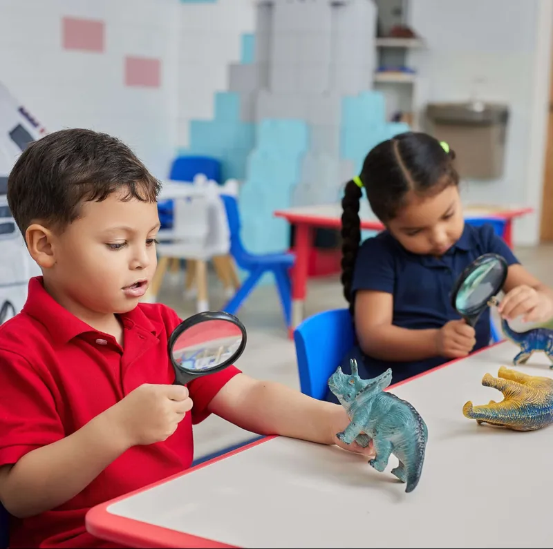 Children exploring plants with a magnifying glass