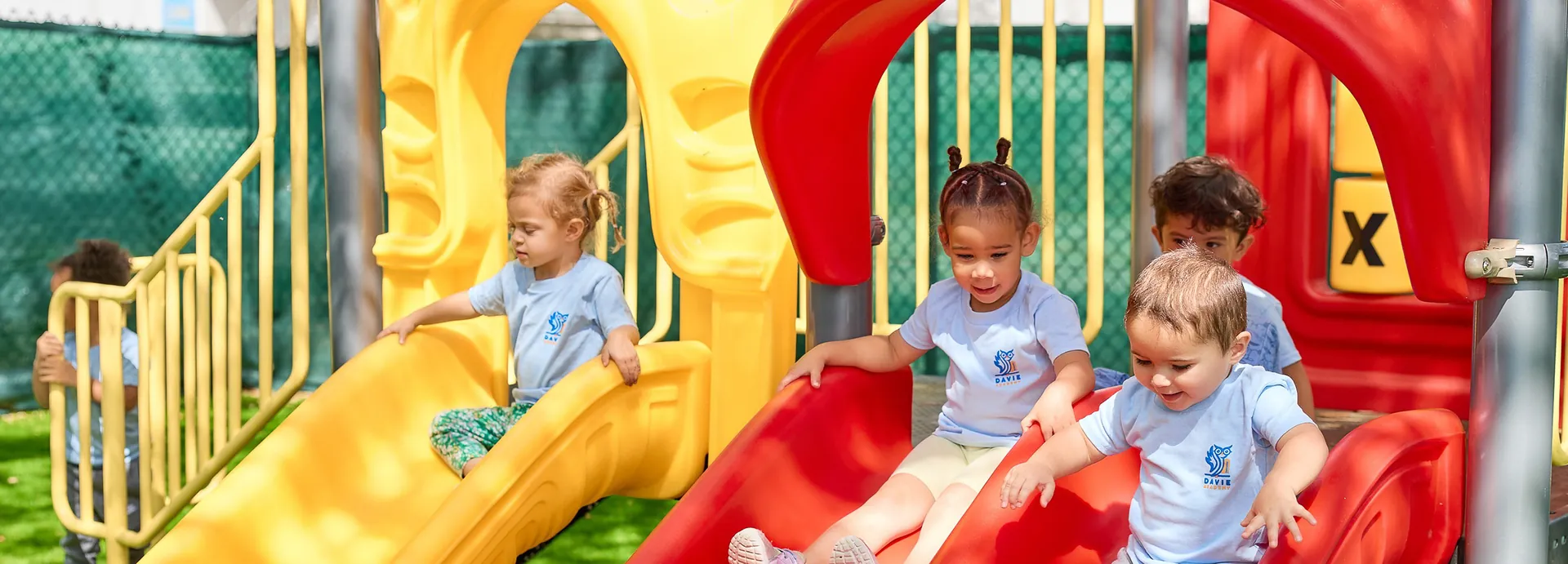 Children playing on the playground slides at Davie Academy